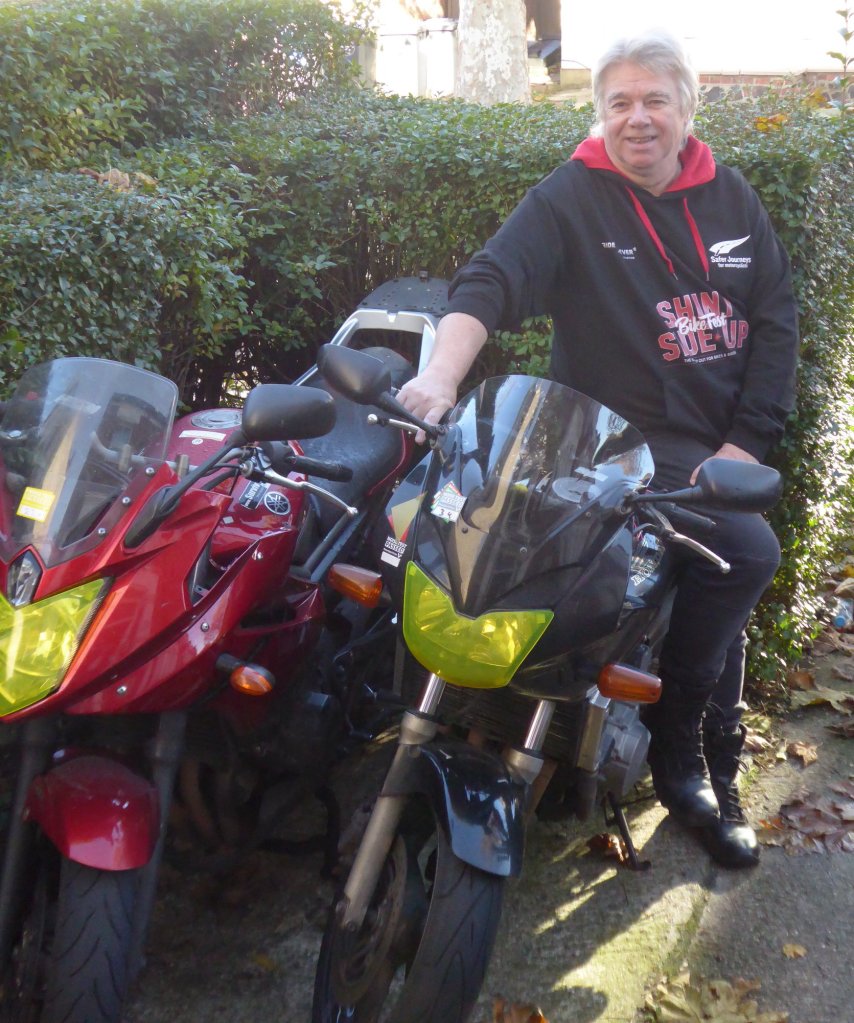 Kevin Williams with two motorcycles with yellow headlight covers